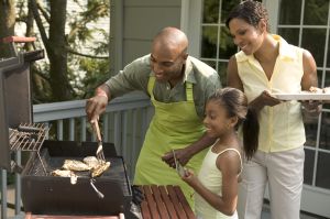 Family Barbecuing Chicken at Home