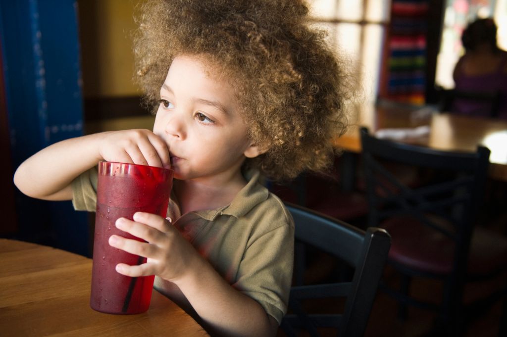 Mixed race boy drinking sofa in restaurant