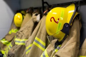 Coats and helmets of fire fighters hanging on hooks